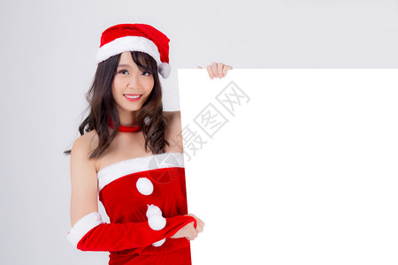 美丽的年轻圣诞老人女子在节假期和新年的广告中展示空的标语纸海报背景图片