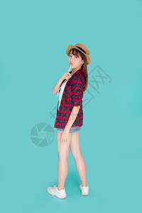 年轻的女戴着帽子带自信的太阳镜享受暑假孤立的蓝色背景旅游模特快乐的Asia女孩思考想法规划旅行概念图片