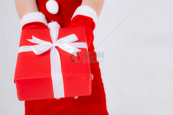 在Xmasday拿着这个盒子的紧贴手与白色背景隔绝的惊喜相提并论女快乐的手臂孩在圣诞节或生日时赠送红色礼物盒带包装纸和白丝图片