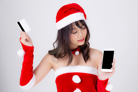 在圣诞节日用智能手机购买信用卡却与白人背景隔绝美貌女孩在圣诞节或新年买礼物图片