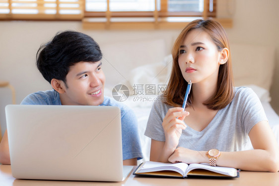 美丽的年轻夫妇计算笔记本电脑和规划费用妇女一起写笔记本或事家庭生活方式家庭和商业概念图片