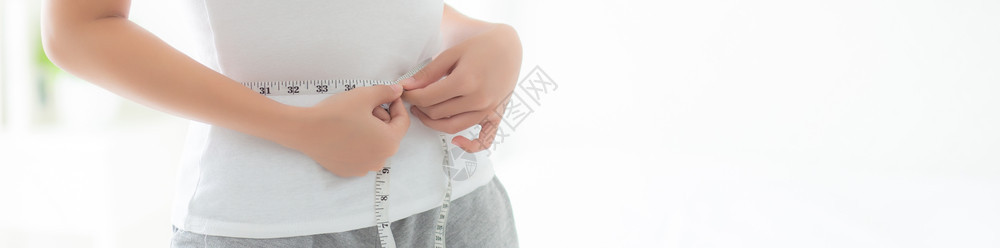 年轻美丽的女在卧室中饮食身瘦腰厚体重女孩有纤维素和卡路里损失磁带测量健康和概念横幅网站图片