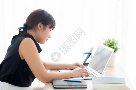 美丽的年轻自由职业女在书桌办公室微笑地工作并用笔记本检查电子邮件或社交网络商业和生活方式概念与专业女孩一起打笔记本电脑图片