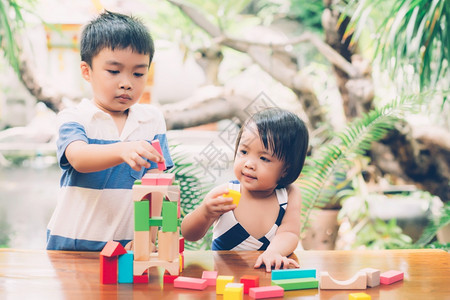 亚洲男孩和笑脸玩木制的块具在桌面上创造和发展享受快乐的儿童学习活动拼图的技能在家桌上玩游戏的创造力教育概念图片