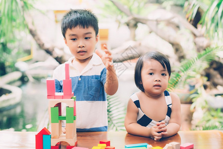 亚洲男孩和笑脸玩木制的块具在桌面上创造和发展享受快乐的儿童学习活动拼图的技能在家桌上玩游戏的创造力教育概念图片