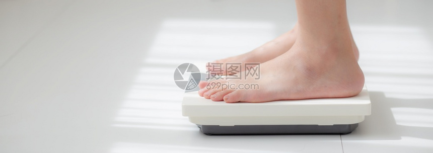 从事活动的妇女腿站着衡量体重比例与赤脚饮食近的瘦女孩减肥措施以控制食物健康护理和概念横幅网站高清图片下载 正版图片 摄图网