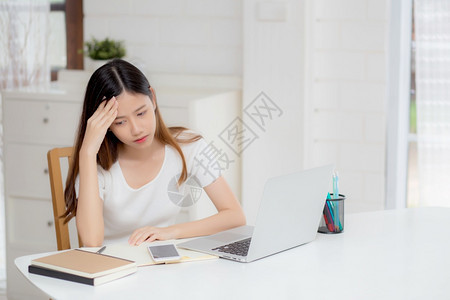 年轻女在使用笔记本电脑时头痛在家办公时间截止女商人疲劳压力焦虑沮丧失败图片