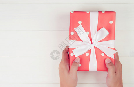 手持礼物的人在圣诞节或假日用木制餐桌上赠送礼物为周年或生日送礼物带影印空间的庆祝活动和喜顶级风景平铺图片