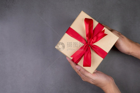 在圣诞节或假日在水泥地板上拿着Kraft礼品盒的人手为周年纪念或生日庆祝活动准备的盒子或带有影印空间的庆祝活动和喜顶级风景平铺图片