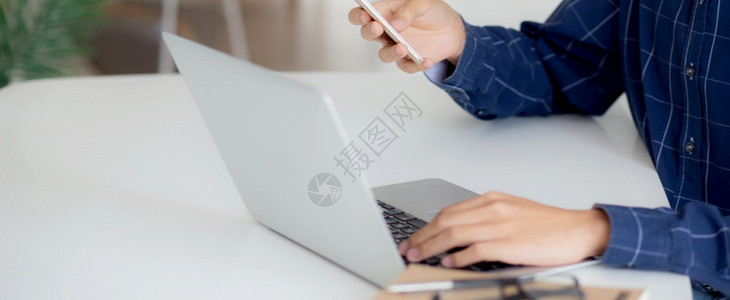 在家书桌上网阅读智能手机自由职业男使用社交媒体商业与流概念的电话图片