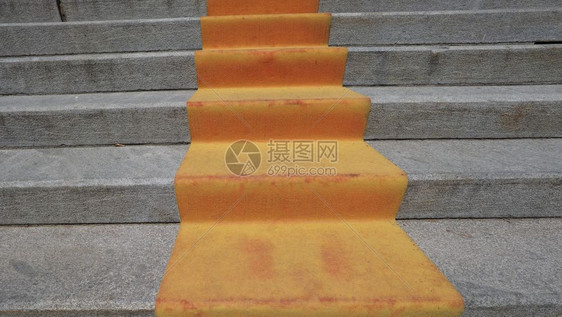 红橙色地毯在楼梯上以标志元首VIP和名人在礼仪正式场合或活动上行进的路线图片
