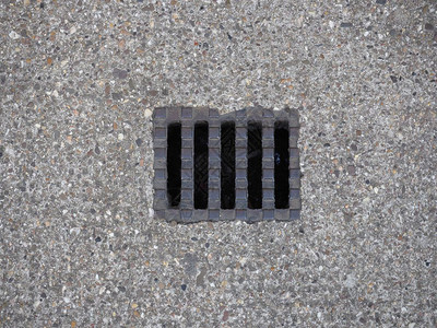 混凝土人行道上的钢排水坑洞图片