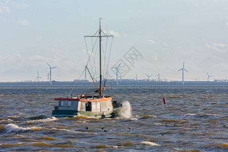 荷兰渔船在有风力涡轮机的ijselmeer湖上图片