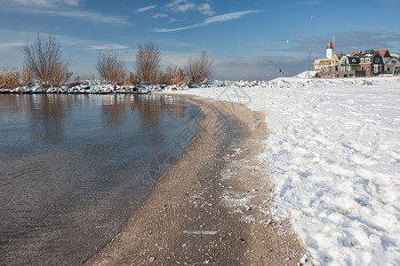 冬季风景荷兰海滩覆盖着雪和鱼村乌尔克的灯塔风景荷兰海滩覆盖着雪和灯塔乌尔克风景图片