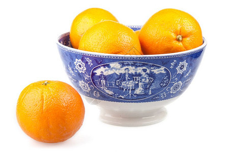 在一个美丽的古老陶瓷手工油漆碗中的橙子图片