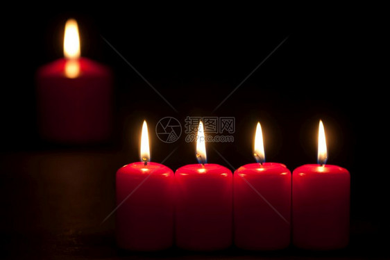 一组红蜡烛在黑暗中燃烧有选择地聚焦图片