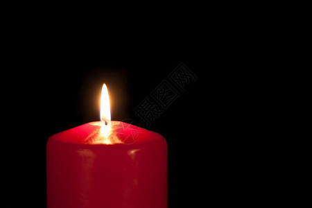 在黑色背景下隔绝的红蜡烛图片