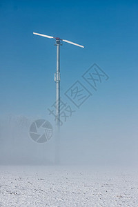 荷兰冬季风景与地面雾和力涡轮机对准蓝天空的荷兰冬季风景与地面雾和力涡轮机的荷兰冬季风景与地面雾和力涡轮机图片