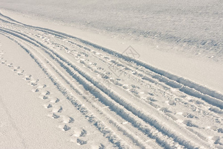 骑脚踏车白雪中的轮胎足迹和脚背景