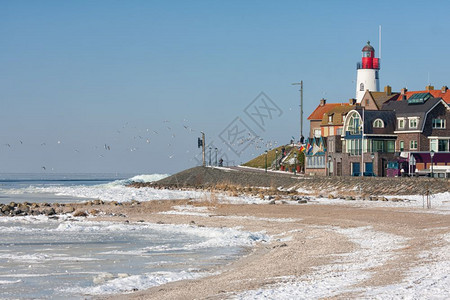 冬季风景荷兰海滩覆盖着雪和鱼村乌尔克的灯塔风景荷兰海滩覆盖着雪和灯塔乌尔克风景图片