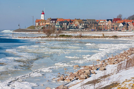 荷兰冬季风景有冰冻的海洋和漂流冰层在乌尔克渔业村的灯塔上背景观察图片