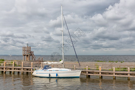 具有历史意义的荷兰乌尔克村港现代游艇停靠在木码头上图片