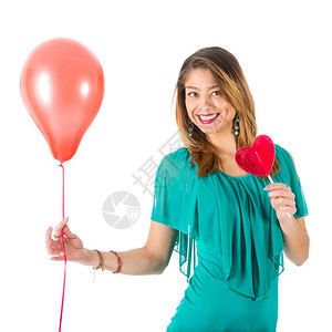美丽的女人拿着红气球和心形棒糖在她面前孤立白色图片
