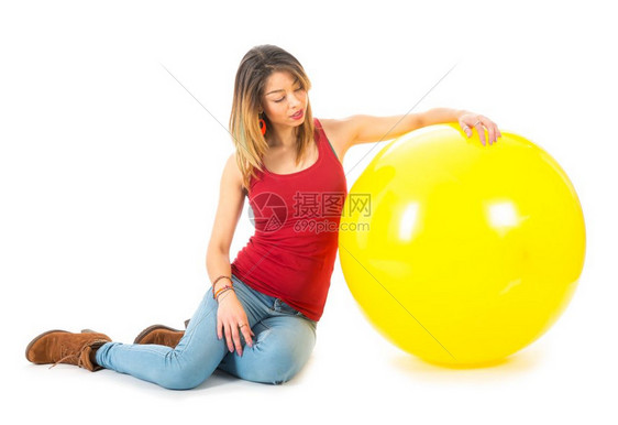 穿着红衬衫的漂亮女人坐在地板上一个白色的黄大气球图片