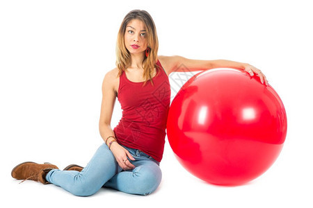穿着红衬衫的漂亮女人坐在地板上一个白色的红气球图片