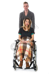 男子将妇女推在轮椅上孤立白色背景上图片