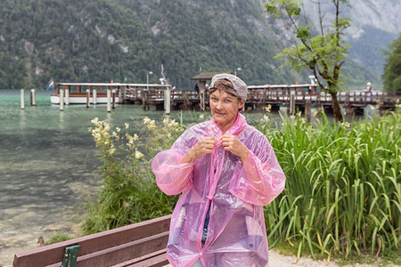 德国阿尔卑斯山脉Berchtestesgaden附近Konigssee海岸有雨衣的妇女图片