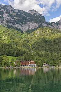 在巴伐利亚阿尔普斯的拉姆苏附近Hintersee湖岸沿线有盛开花和旅馆在巴伐利亚阿尔普斯的拉姆苏附近Hintersee湖和酒店图片