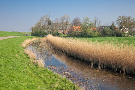 荷兰村庄Gaast和教堂后面的大坝有教堂坝海保护的荷兰村庄Gaast图片