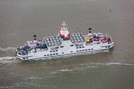 荷兰在瓦登海的渡船载有乘客和汽车从Holwerd驶往阿梅兰岛在Wadden海的荷兰渡船驶往Beween沙滩图片