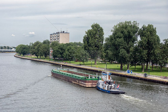 乌得勒支市附近的荷兰阿姆斯特丹Rijn运河上载有空货船的拖乌得勒支市附近的荷兰阿姆斯特丹Rijn运河上载有货物的拖船图片