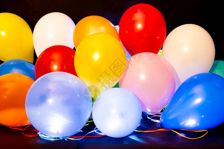 在黑暗背景下以内部LED灯光照亮的多彩气球在黑暗背景下以LED灯光照亮的彩色气球图片