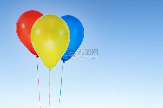 三个红色黄的蓝气球用于生日和在蓝天空孤立的庆祝活动并复制免费文字空间图片