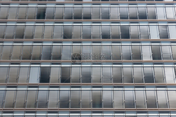 现代办公大楼外墙的灰色遮太阳面对称背景现代办公大楼外面灰色遮太阳的对称背景图片