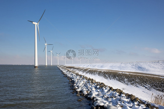 冬季沿杜奇海岸的长排离风涡轮松雪冬季沿杜奇海岸的离风涡轮松雪冬季沿杜奇海岸的离风涡轮松和雪图片