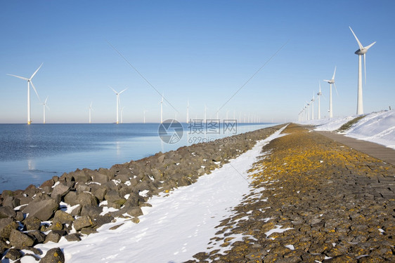 冬季沿杜奇海岸的长排离风涡轮松雪冬季沿杜奇海岸的离风涡轮松雪冬季沿杜奇海岸的离风涡轮松和雪图片