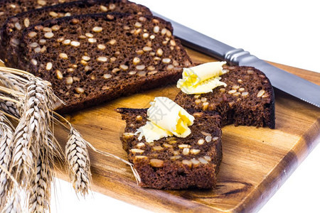 Rye面包木制厨房板上有谷物和黄油工作室照片木制厨房板上有谷物和黄油图片