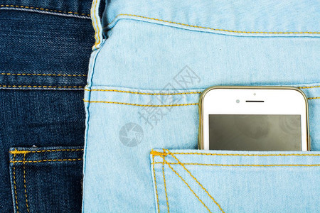 蓝色牛仔裤口袋中的移动电话图片