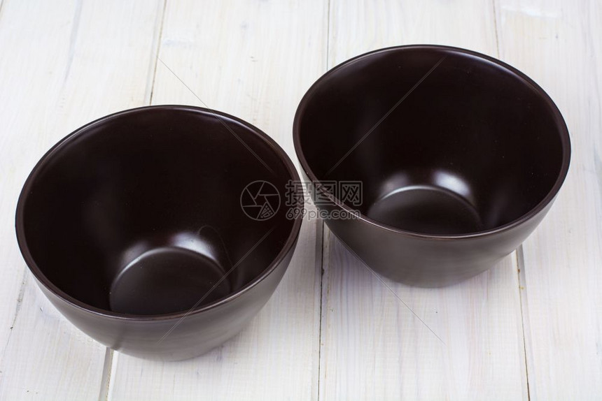 Brown陶瓷碗白色木制背景工作室照片图片