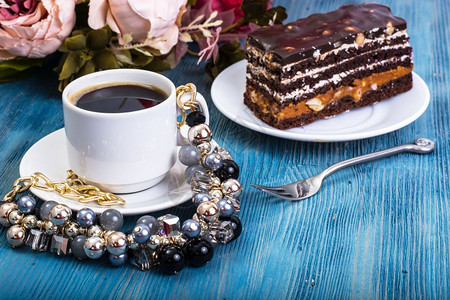 巧克力海绵蛋糕含焦糖的巧克力海绵蛋糕和蓝背景的坚果工作室照片巧克力海绵蛋糕含焦糖的巧克力海绵蛋糕和蓝背景的坚果图片