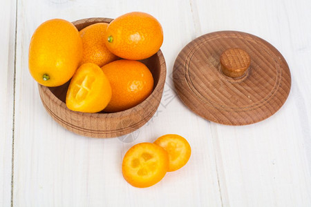 白色木制背景的小型成熟橙子库姆夸特工作室照片图片