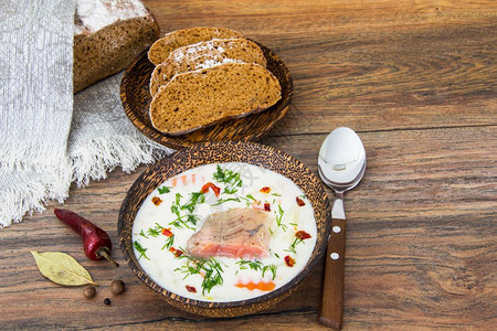 俯视图棕色面包和木碗中的鲑鱼奶油汤图片