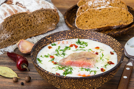 棕色面包和木碗中的鲑鱼奶油汤图片
