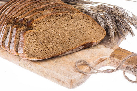 Rye面包切在厨房木板上耳朵和谷物工作室照片图片