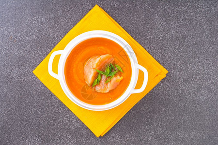 橘色餐布上的胡萝卜南瓜奶油汤加鲑鱼图片
