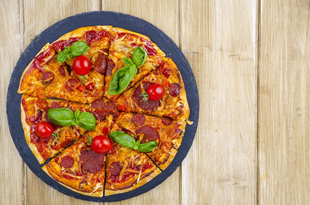 配有腊肠奶酪和新鲜蔬菜的披萨配有腊肠奶酪和新鲜蔬菜的披萨图片